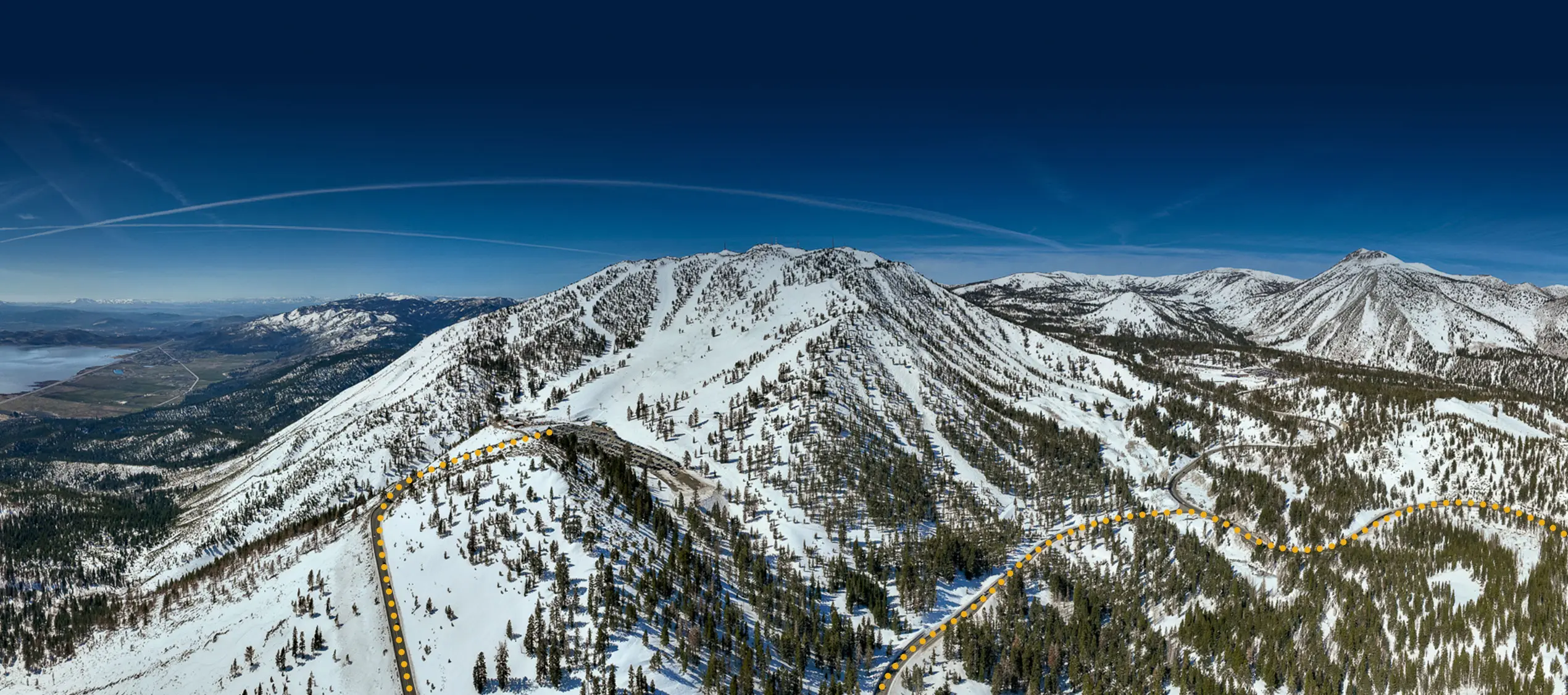Aerial view of a snow-covered mountain range labeled "SLIDE BOWL" with a yellow dotted line marking a Nevada skiing route and a red star near the mountain ridge. Mt. Rose Ski Tahoe