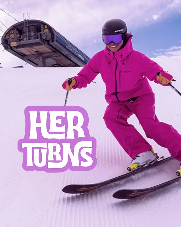 A skier in a bright pink outfit skis down a groomed slope near a ski lift at Ski Tahoe, with the text "HER TURNS" in bold, stylized letters overlaid on the image. Mt. Rose Ski Tahoe