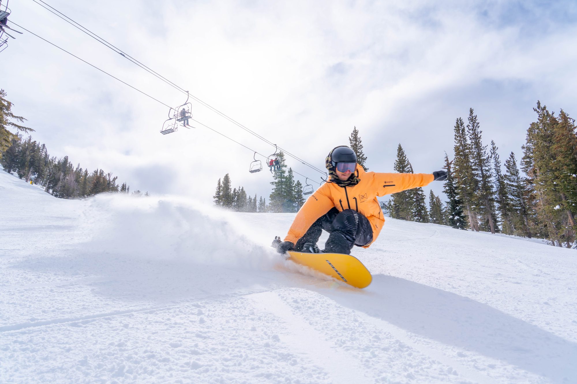 A person on a snowboard carves down the snowy slopes, capturing the thrill of a Ski Tahoe adventure. Mt. Rose Ski Tahoe